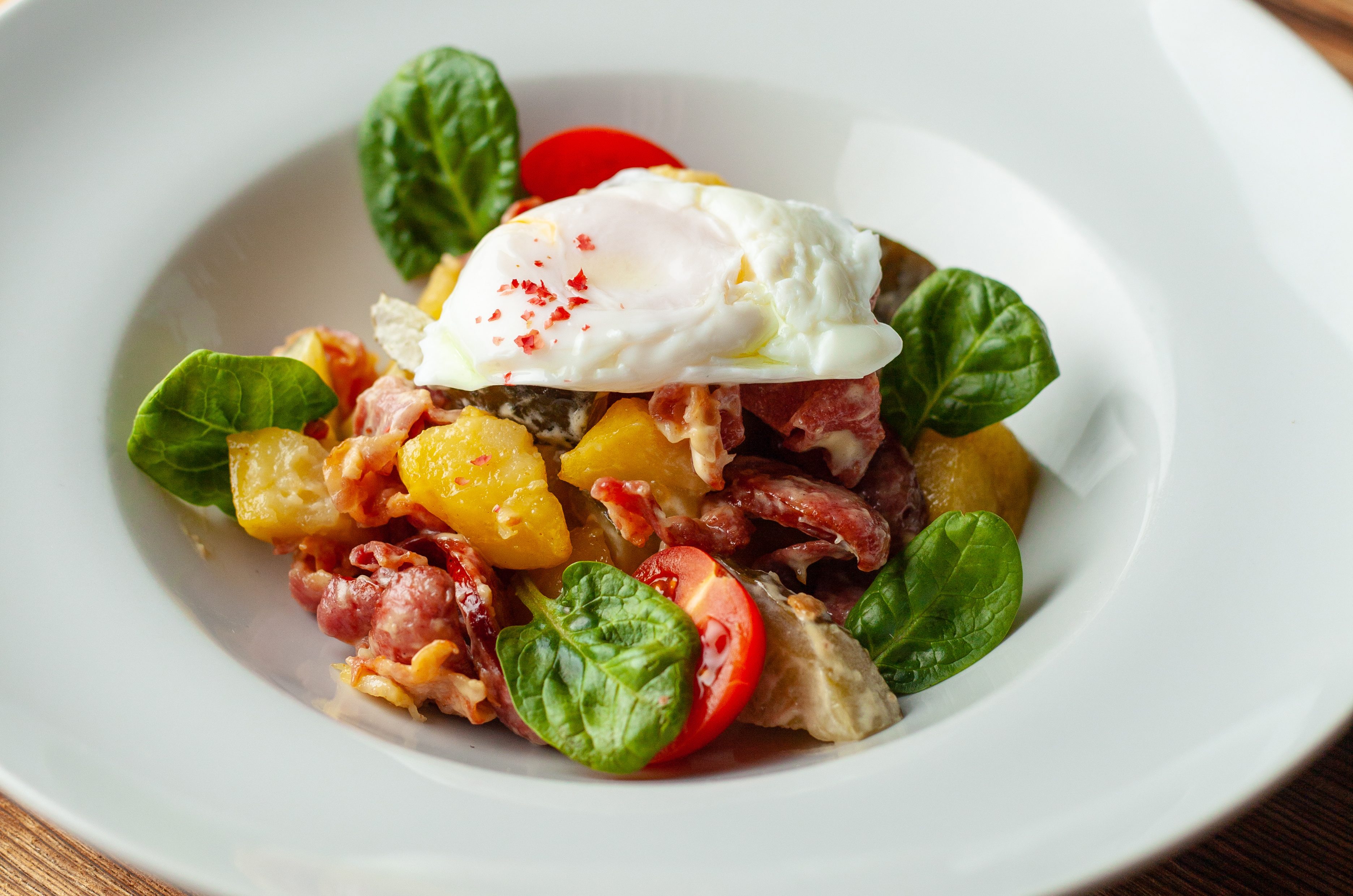 Rustic salad with, tomatoes, chorizo sausage, poached egg, spinach, potato and pickled cucumber for nutritious dinner, served on wooden table, Rustic salad with, tomatoes, chorizo sausage, poached egg, spina