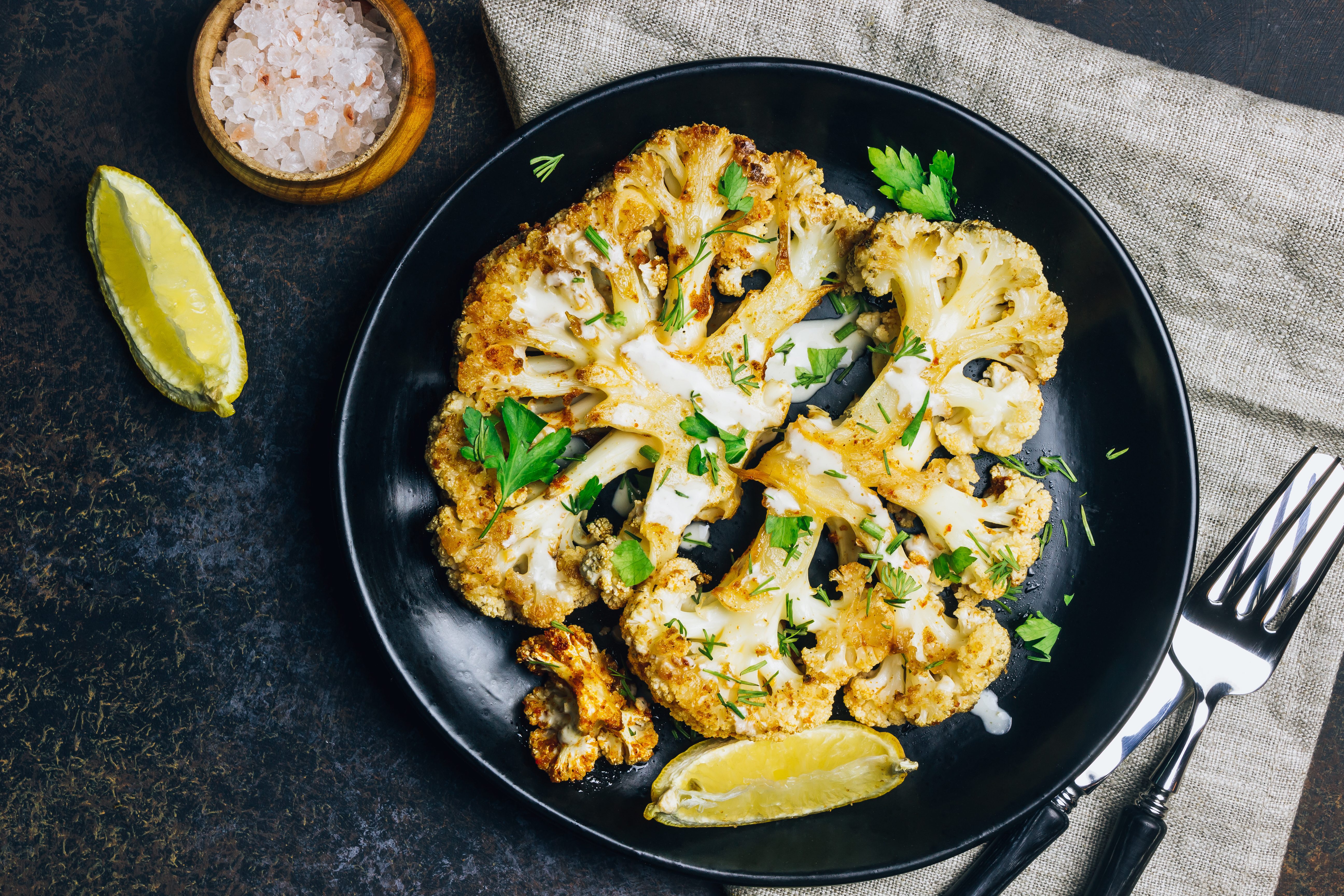 Fried cauliflower steak with greens and spices.