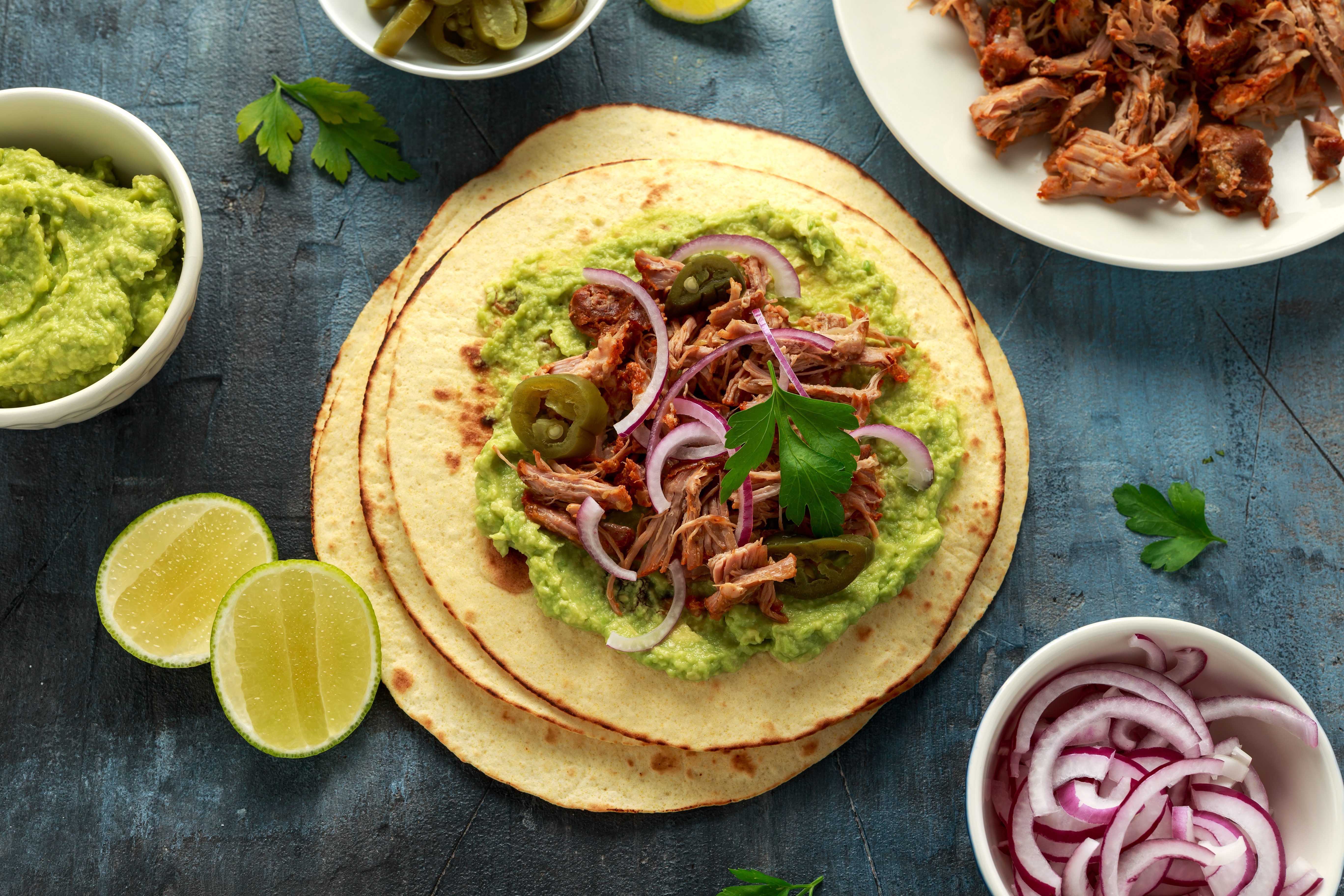 Mexican Corn tortilla with shredded Pork, avocado, red onion and jalapeno